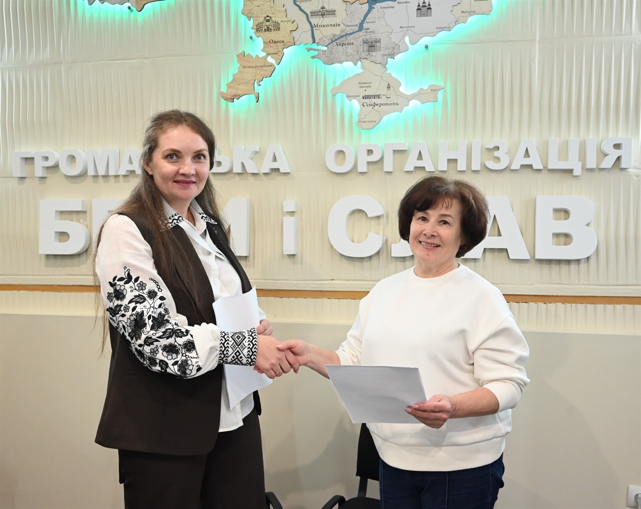 жінки тиснуть одна одній руки